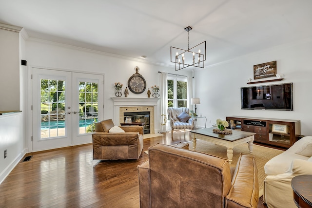 living room featuring a chandelier, dark hardwood / wood-style floors, french doors, and ornamental molding