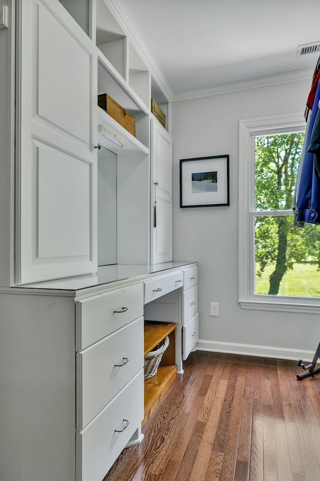 mudroom featuring dark hardwood / wood-style floors, ornamental molding, and built in desk