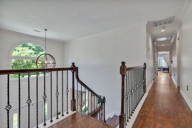 hall featuring ornamental molding, dark wood-type flooring, and a chandelier