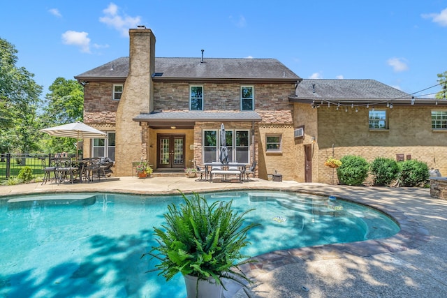 view of pool with french doors and a patio