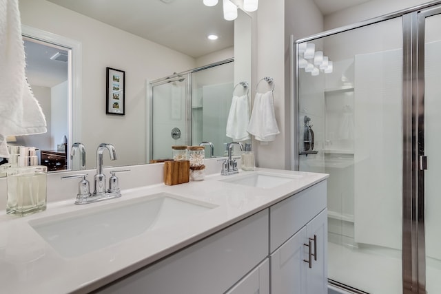 bathroom featuring an enclosed shower and double vanity