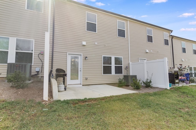 back of house with central AC, a lawn, and a patio area