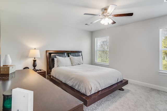 bedroom featuring multiple windows, light carpet, and ceiling fan