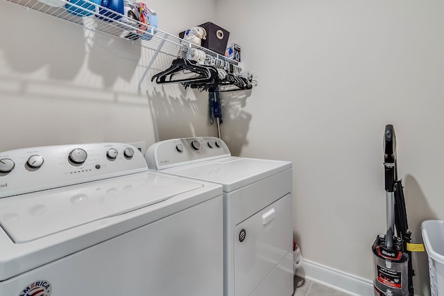 clothes washing area featuring separate washer and dryer and light tile floors