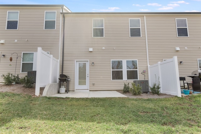 rear view of property featuring a lawn, central air condition unit, and a patio