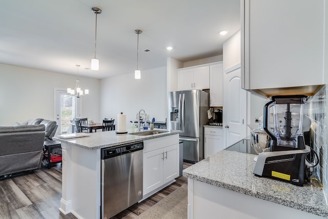 kitchen featuring hanging light fixtures, stainless steel appliances, light stone countertops, dark hardwood / wood-style floors, and white cabinets