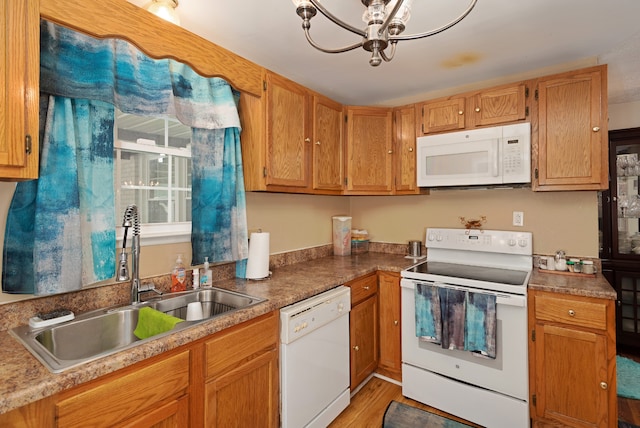 kitchen featuring light hardwood / wood-style floors, an inviting chandelier, white appliances, and sink