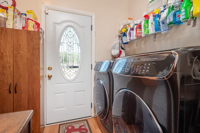 laundry room with light wood-type flooring and washer and clothes dryer