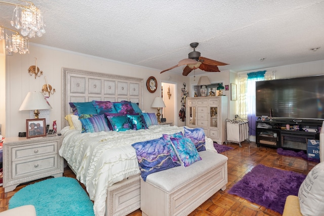 bedroom with a textured ceiling, dark parquet flooring, and ceiling fan with notable chandelier