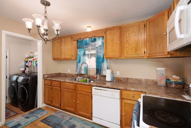 kitchen with white appliances, sink, light hardwood / wood-style flooring, washer and clothes dryer, and a chandelier