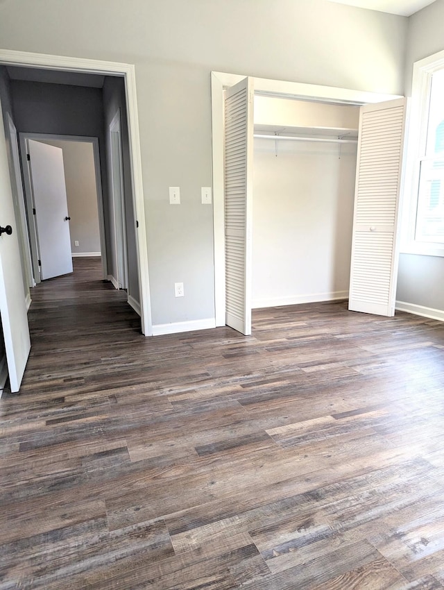 unfurnished bedroom featuring a closet and dark hardwood / wood-style floors