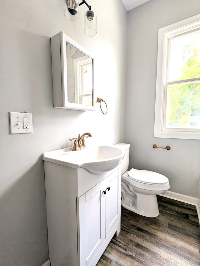 bathroom featuring toilet, hardwood / wood-style floors, and vanity