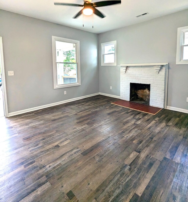 unfurnished living room with a fireplace, ceiling fan, and dark hardwood / wood-style flooring