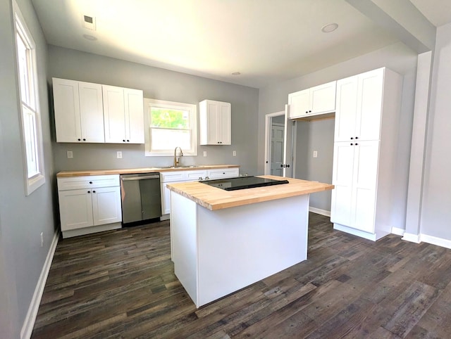 kitchen featuring butcher block counters, white cabinets, and stainless steel dishwasher