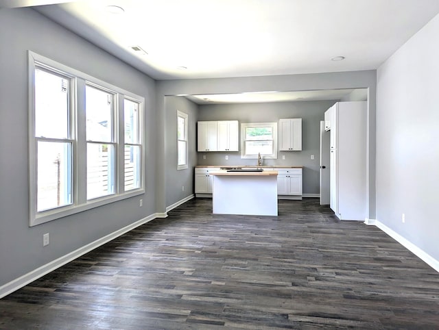 kitchen featuring a kitchen island, white cabinetry, dark wood-type flooring, and sink