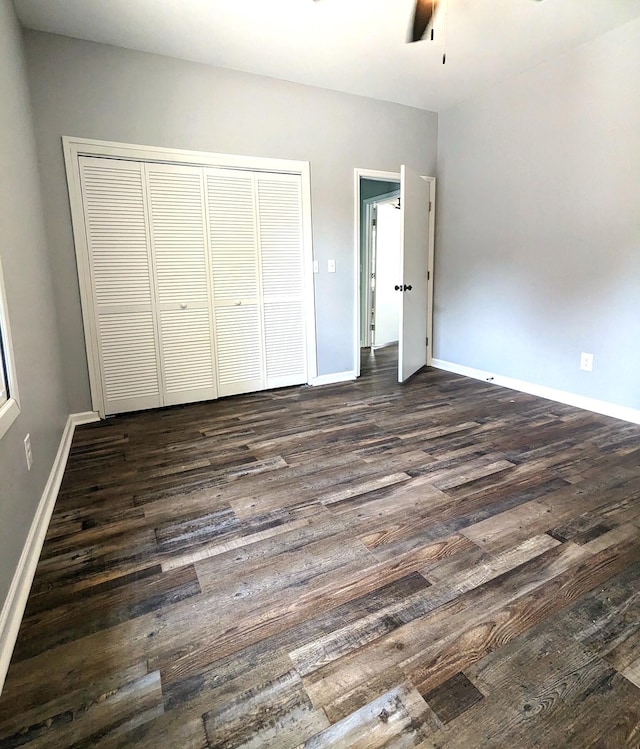 unfurnished bedroom featuring a closet, ceiling fan, and dark wood-type flooring