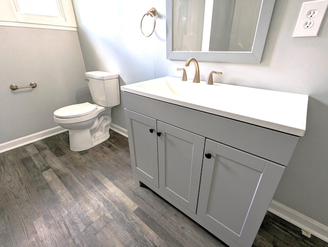 bathroom with toilet, wood-type flooring, and vanity