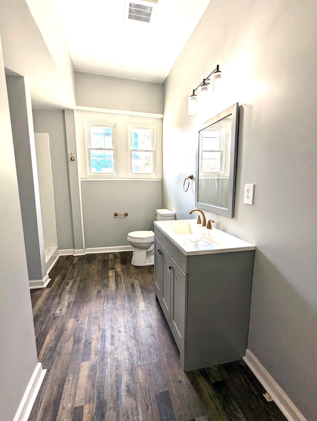 bathroom with vanity, toilet, and hardwood / wood-style flooring