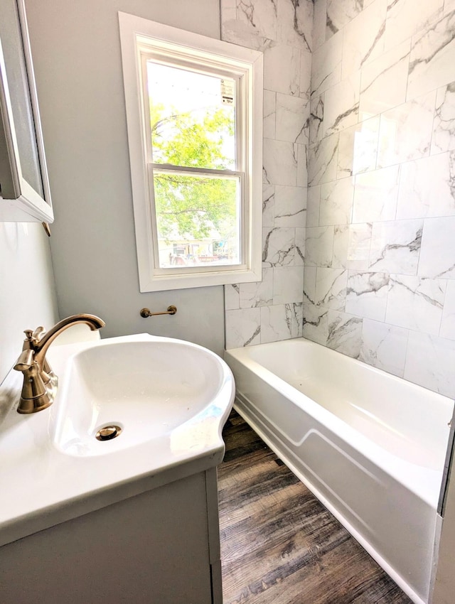 bathroom with vanity, tiled shower / bath combo, and hardwood / wood-style flooring