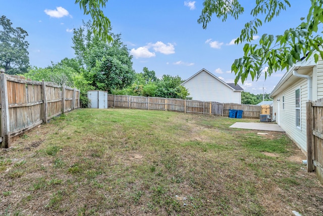 view of yard with a shed, a patio area, and central air condition unit