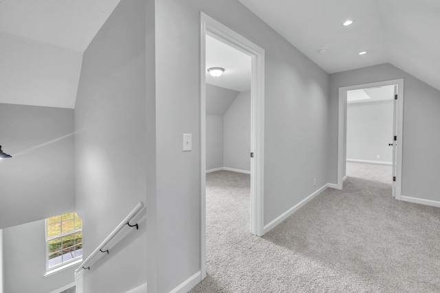 bonus room with vaulted ceiling and light colored carpet