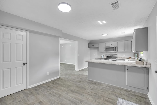 kitchen with kitchen peninsula, light hardwood / wood-style flooring, and appliances with stainless steel finishes