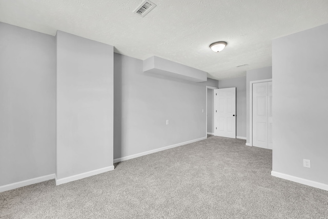 carpeted empty room with a textured ceiling