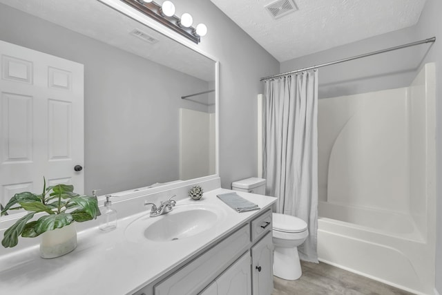 full bathroom featuring toilet, a textured ceiling, vanity, shower / bathtub combination with curtain, and hardwood / wood-style flooring