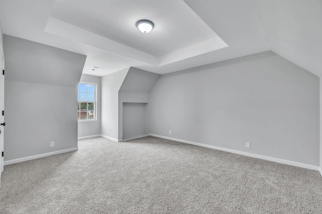 additional living space featuring lofted ceiling and light colored carpet