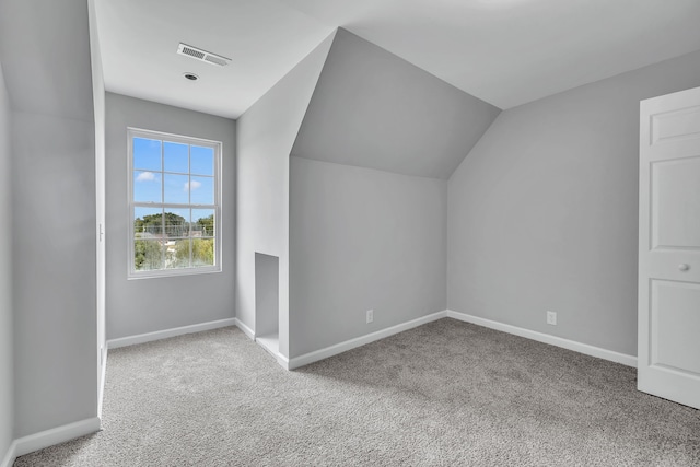 bonus room featuring light carpet and vaulted ceiling