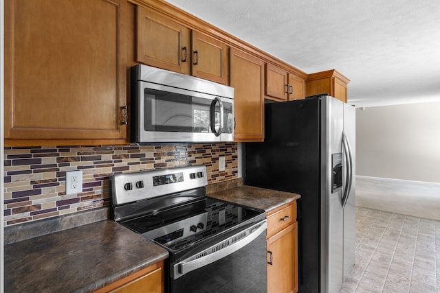 kitchen with appliances with stainless steel finishes, light carpet, and tasteful backsplash