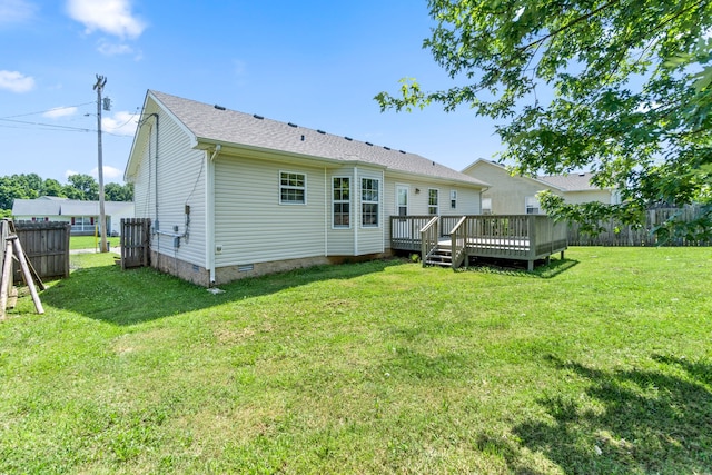 rear view of property featuring a deck and a lawn