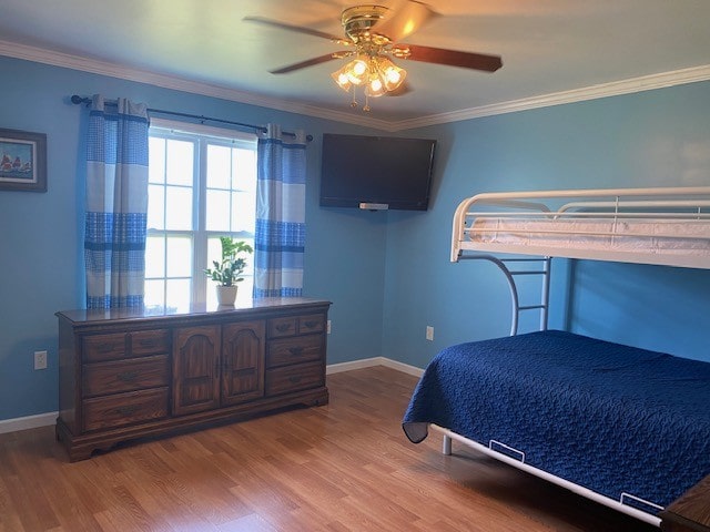 bedroom featuring crown molding, wood-type flooring, and ceiling fan