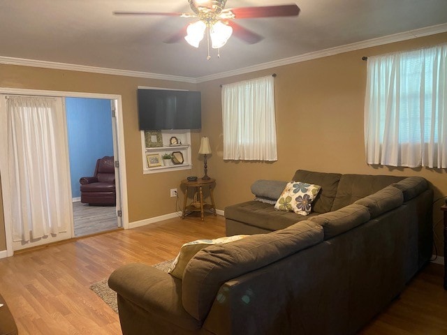 living room with crown molding, ceiling fan, and light hardwood / wood-style flooring