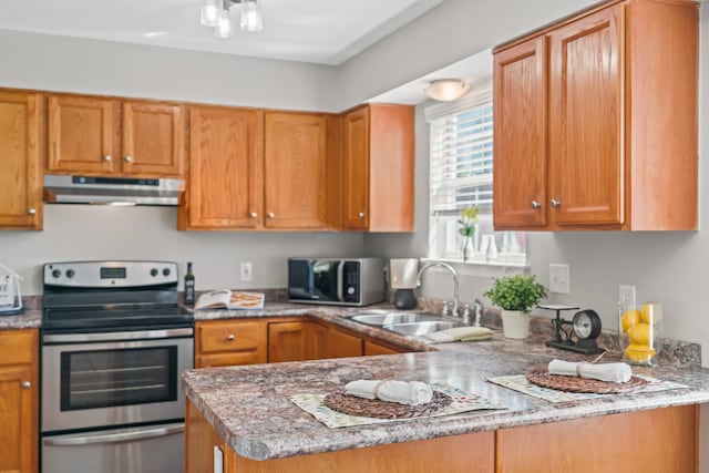 kitchen with an inviting chandelier, appliances with stainless steel finishes, light stone countertops, and sink