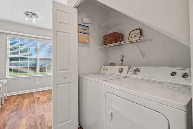 washroom with washer and dryer, a wealth of natural light, and light hardwood / wood-style flooring