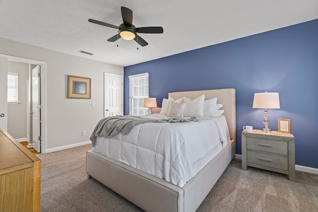 carpeted bedroom featuring ceiling fan and multiple windows