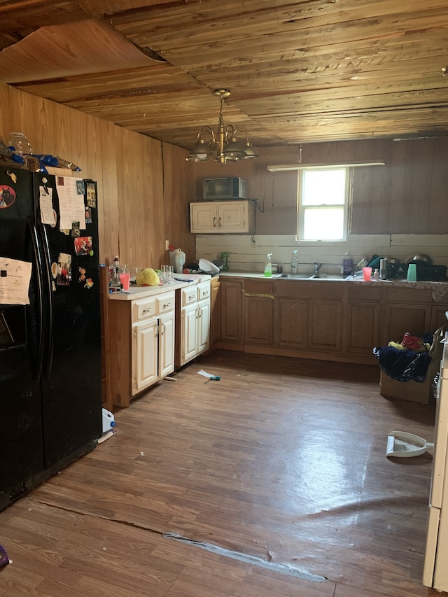 kitchen featuring a notable chandelier, wood ceiling, black refrigerator, and wood-type flooring