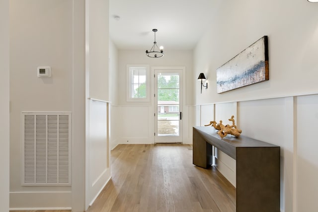 entryway with an inviting chandelier and light hardwood / wood-style floors