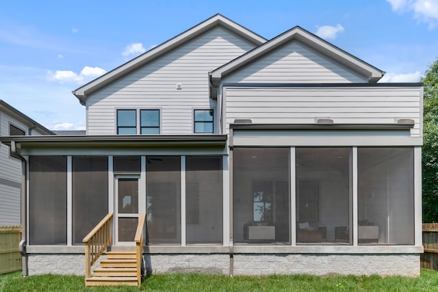 rear view of house featuring a sunroom