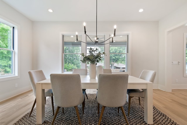 dining area featuring a healthy amount of sunlight, light hardwood / wood-style floors, and an inviting chandelier