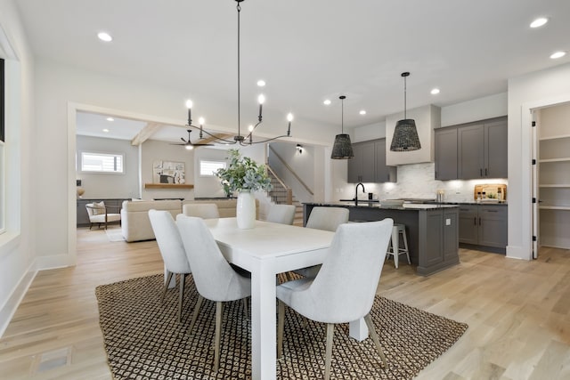 dining room with light hardwood / wood-style flooring, sink, and an inviting chandelier