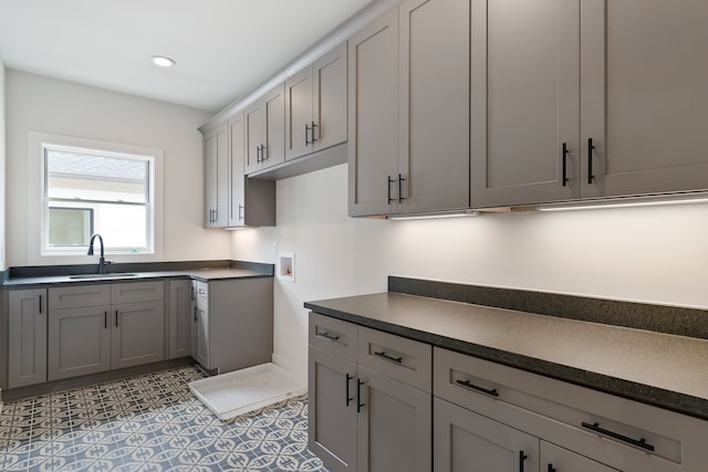 kitchen featuring light tile floors, gray cabinets, and sink