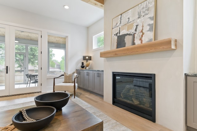 living room with french doors, light hardwood / wood-style flooring, and beam ceiling