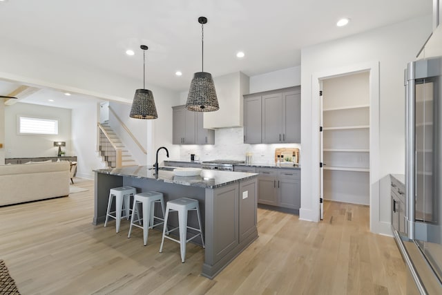 kitchen featuring decorative light fixtures, gray cabinetry, and light wood-type flooring