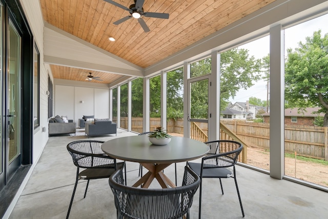 sunroom / solarium with lofted ceiling, wooden ceiling, and ceiling fan