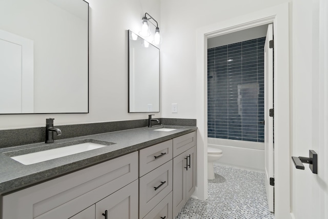 full bathroom featuring tile floors,  shower combination, double sink, toilet, and vanity with extensive cabinet space