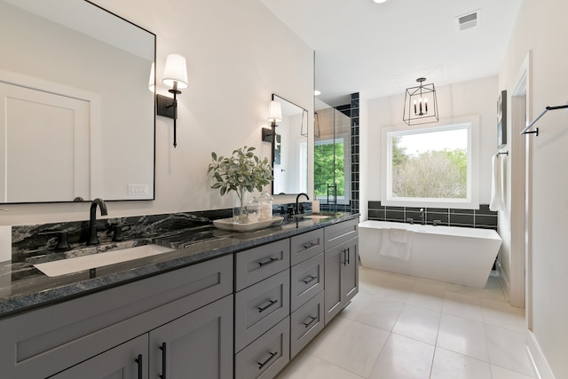 bathroom featuring double vanity, tile flooring, and a tub