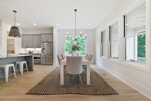 dining space with a notable chandelier and light wood-type flooring