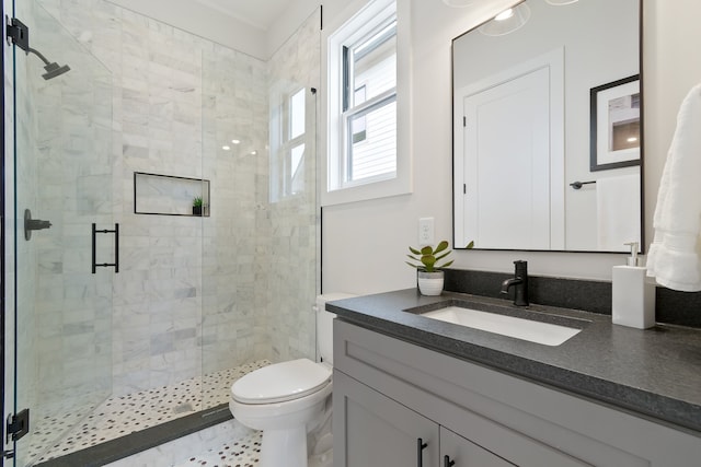 bathroom featuring tile floors, toilet, large vanity, and walk in shower